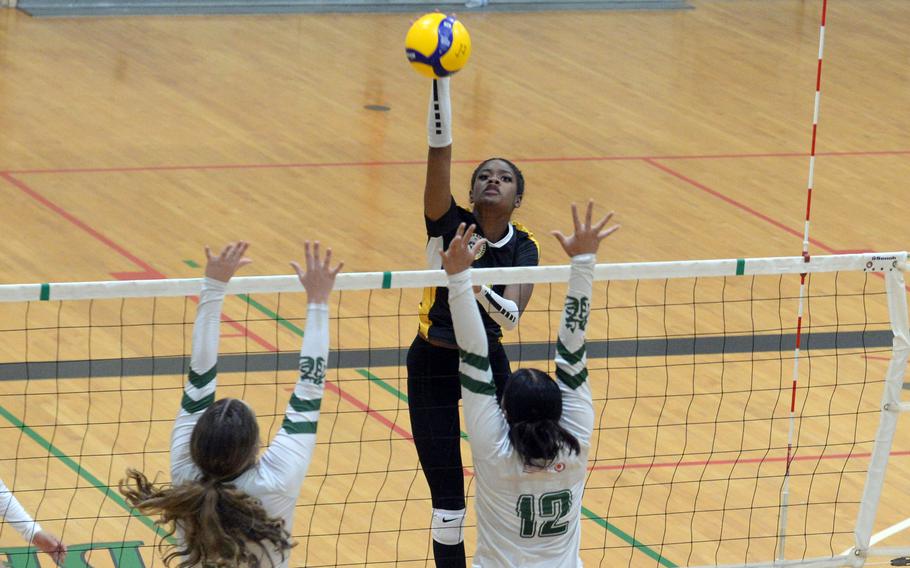 Kadena's Liza Young spikes against Kubasaki's Hailey Brassard and Ayeli Rocha during Tuesday's Okinawa girls volleyball match. The Panthers won in five sets.