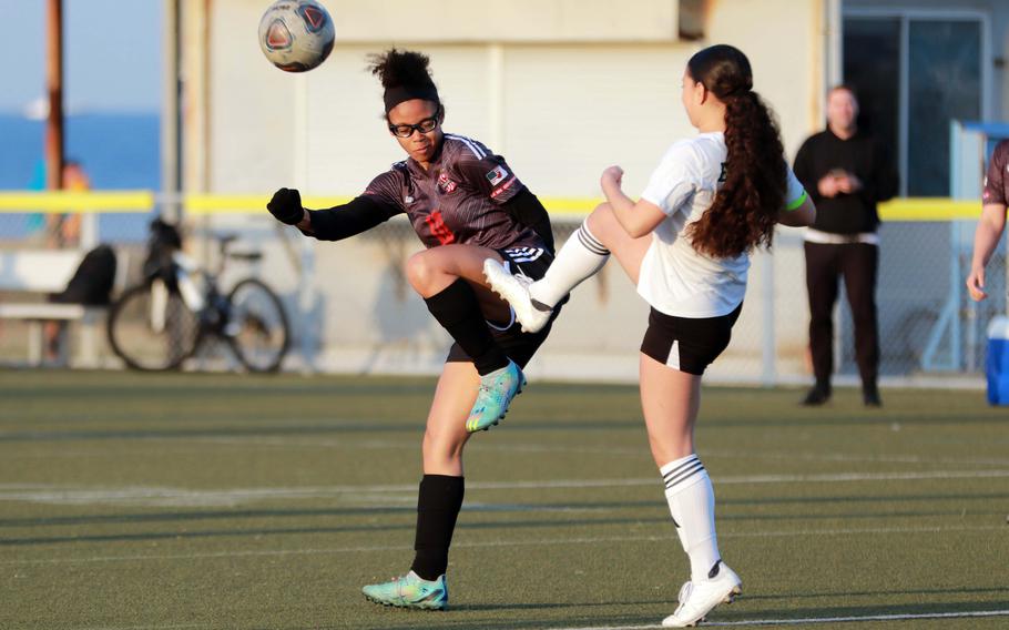 Nile C. Kinnick's Jaylah Petty and Robert D. Edgren's Aliyah Torres try to play the ball during Friday's DODEA-Japan girls soccer match. The Red Devils won 11-0.
