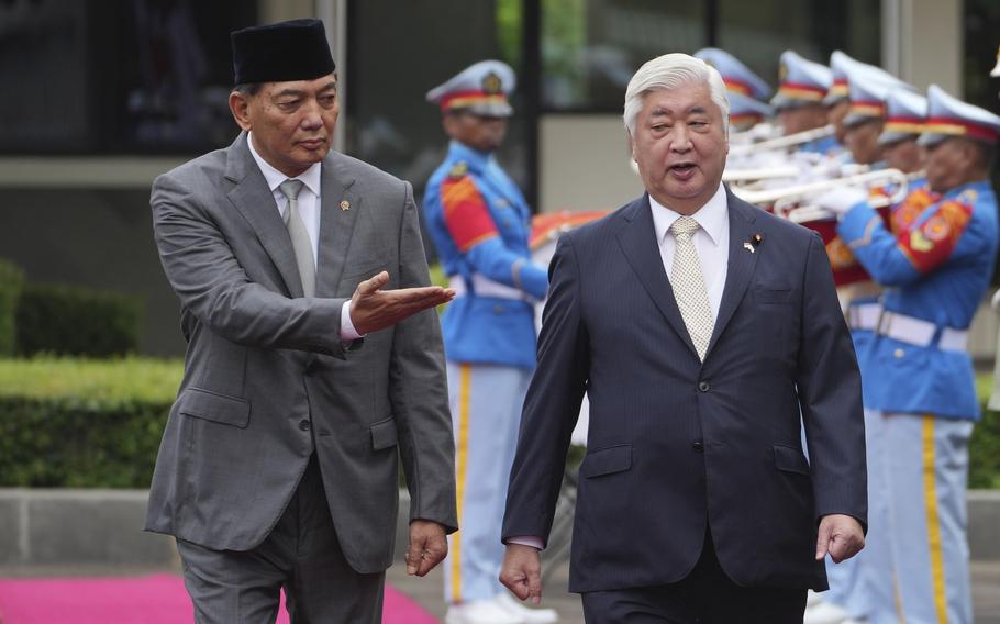 Minister of Defense of Indonesia Sjafrie Sjamsoeddin gestures toward Japan’s Defense Minister Gen Nakatani.