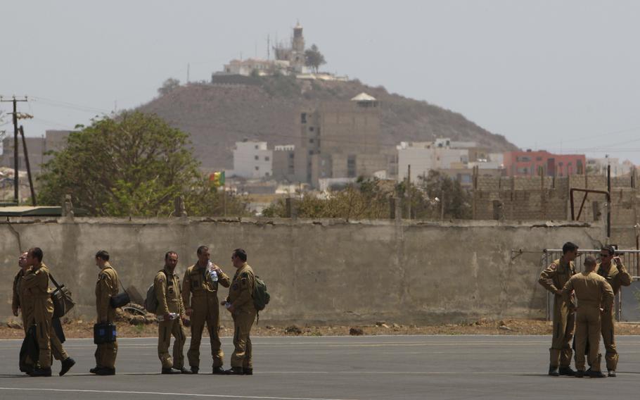 Members of a French military flight crew talk on the tarmac