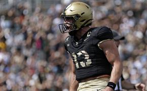 Army quarterback Bryson Daily shouts in celebration after scoring a touchdown in a college football game.