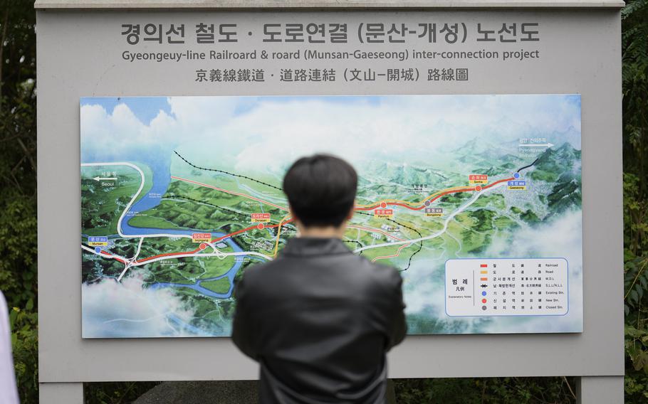 A man stands in front of a map of a railroad.