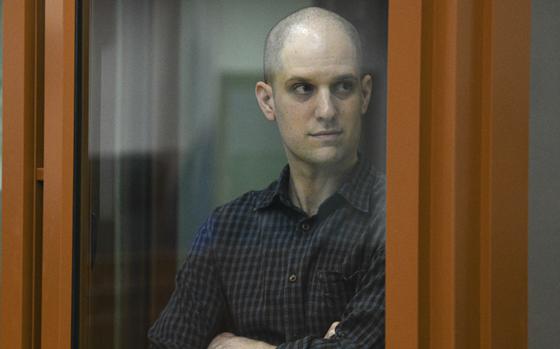 Evan Gershkovich stands in a glass cage during a court appearance in Yekaterinburg, Russia, on June 26, 2024.