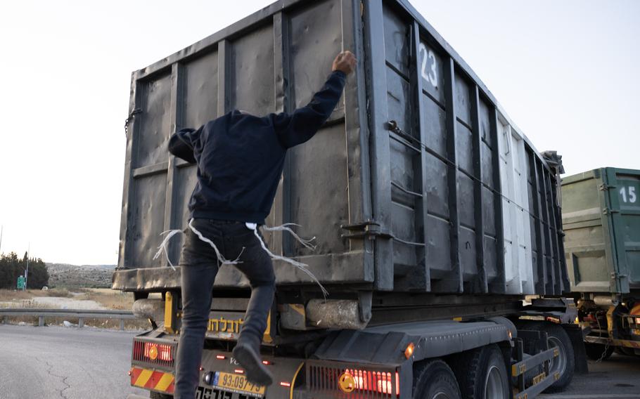 Yosef de Bresser, 23, a right-wing protest leader, jumps on the back of a truck he suspected was transporting aid from Jordan to Gaza, through the Tarqumiyah crossing. 