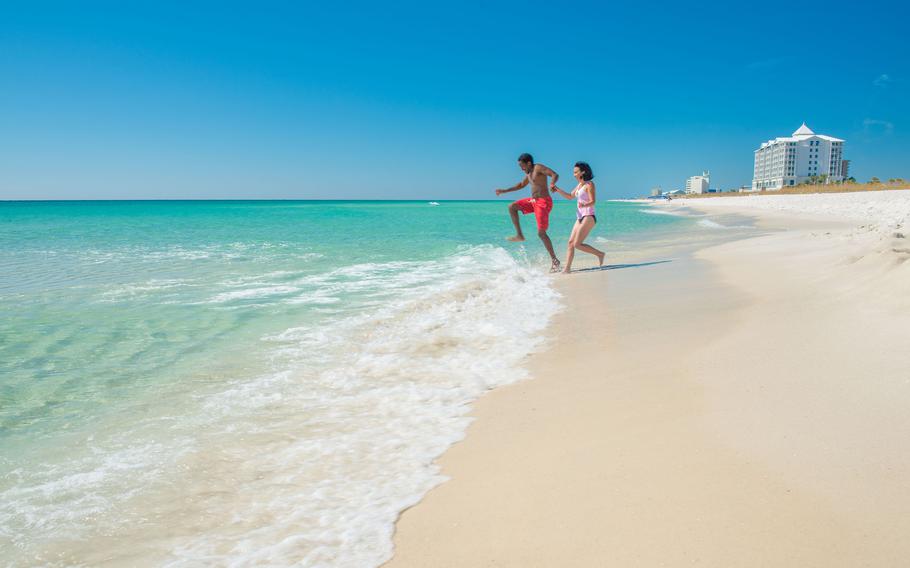 Vacationers enjoy a dip at Pensacola Beach in Pensacola, Fla. 