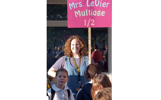 Mannheim, Germany, Sep.7, 2004: Jennifer LeVier, a multi-age first- and second-grade teacher at Mannheim Elementary School, smiles as she welcomes pupils lining up for class on the first day of school.

Check out Stars and Stripes' community sites for all the DODEA Back to School events and news. 
https://www.stripes.com/communities/

META TAGS: DODEA; military kids; back to school; dependents; 