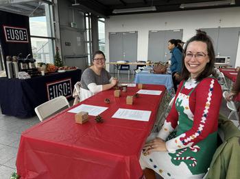 Two women sitting at table at USO event