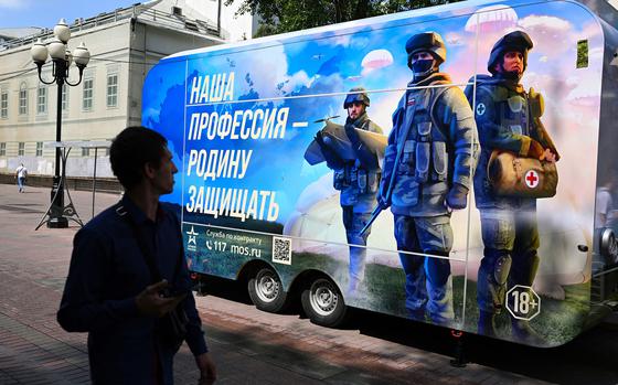 A man walks past a contract army service mobile recruitment point in Moscow on July 6, 2023. (Natalia Kolesnikova/AFP/Getty Images/TNS)