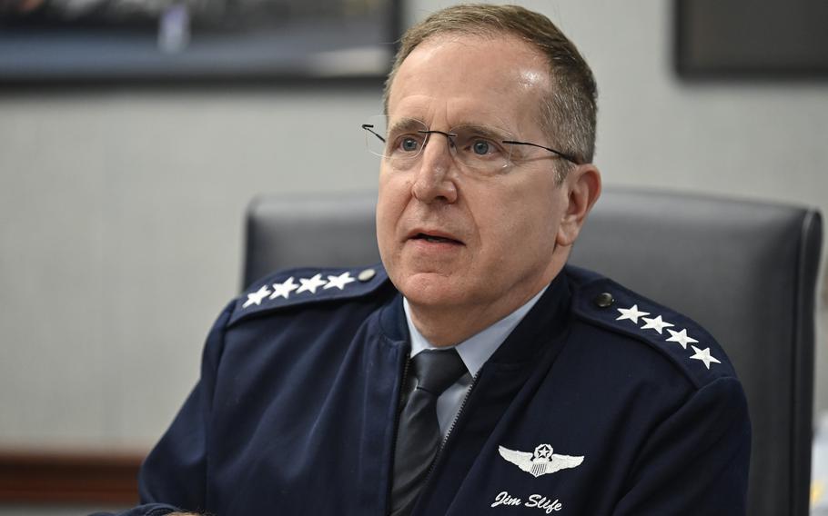 An Air Force officer in uniform sits at a desk in an office.