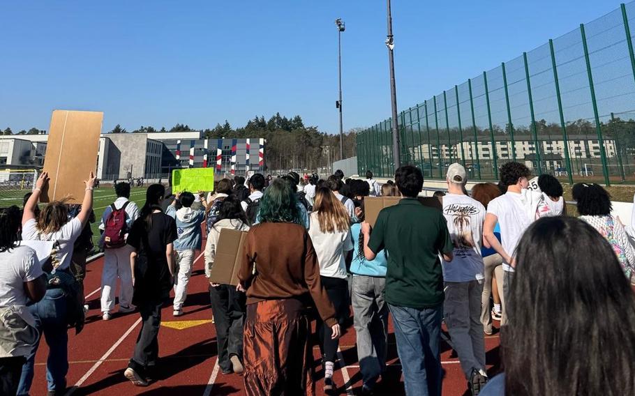 A group of students walk together around a track