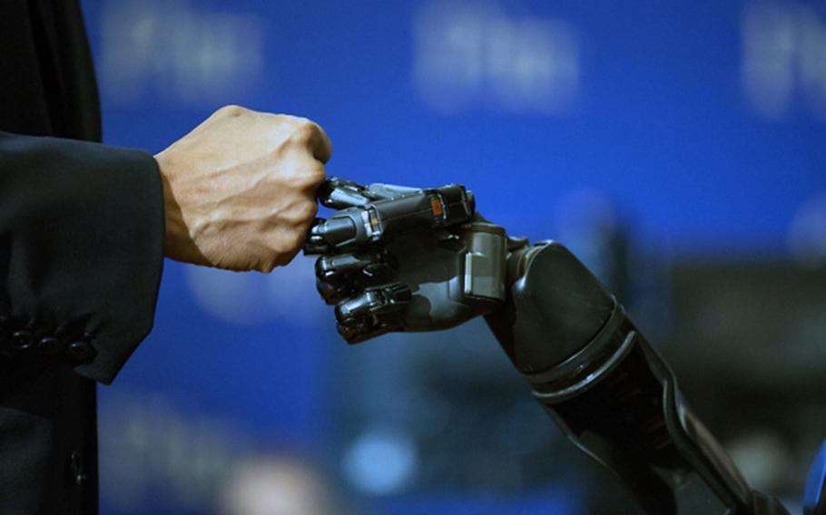 President Barack Obama fist-bumps the robotic arm of Nathan Copeland at the University of Pittsburgh on Oct. 13, 2016. 