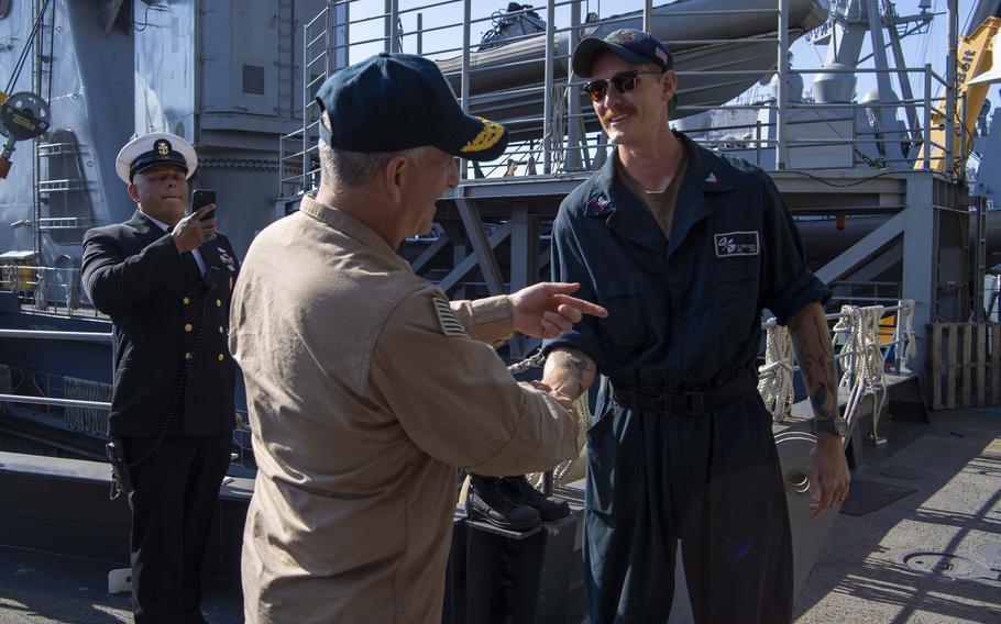 Rear Adm. Ted LeClair, deputy commander, Naval Surface Forces, U.S. Pacific Fleet, shakes hands with Gunner’s Mate 2nd Class Rider Morrissey 