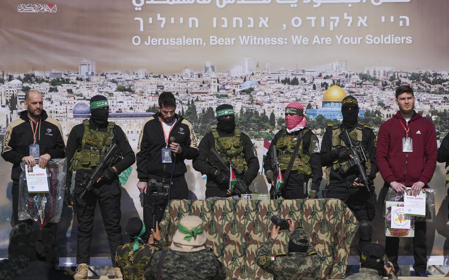 Israeli hostages Iair Horn, 46, left, Sagui Dekel Chen, 36, center left, and Alexander Troufanov, 29, right, are escorted by Hamas and islamic Jihad fighters as they are handed over to the Red Cross in Khan Younis, Gaza Strip, Saturday, Feb. 15, 2025.