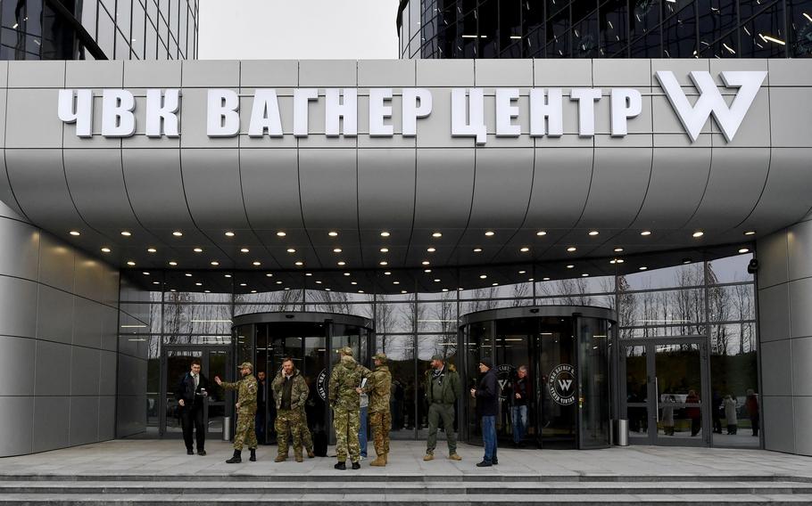 Visitors wearing military camouflage stand at the entrance of the PMC Wagner Center, associated with the founder of the Wagner private military group, Yevgeny Prigozhin, in St. Petersburg, Russia, on Nov. 4, 2022. 