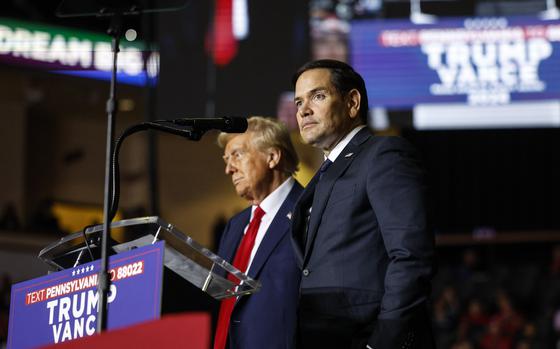 Marco Rubio stands next to Donald Trump on a stage.