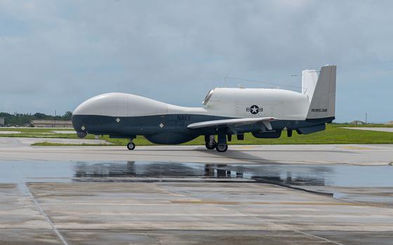 A military drone sits on a runway.