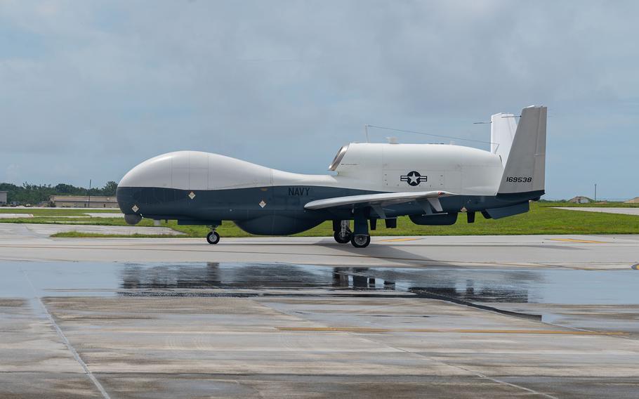 A military drone sits on a runway.