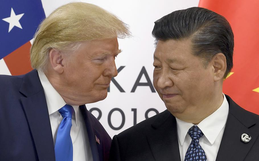 Donald Trump stands closely and looks at China’s Xi Jinping.