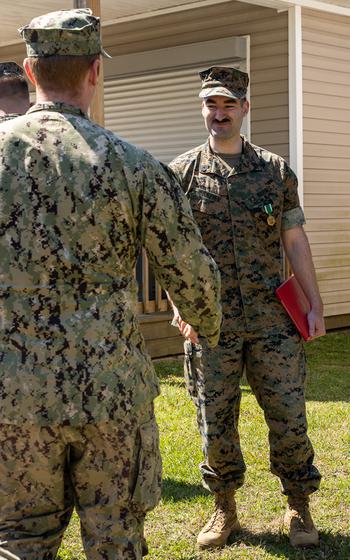 U.S. Marine Corps Gunnery Sgt. Benjamin Frazier shakes hands after being awarded the Navy and Marine Corps Commendation Medal at Naval Air Station Dam Neck, Va., Thursday, March 21, 2024. 