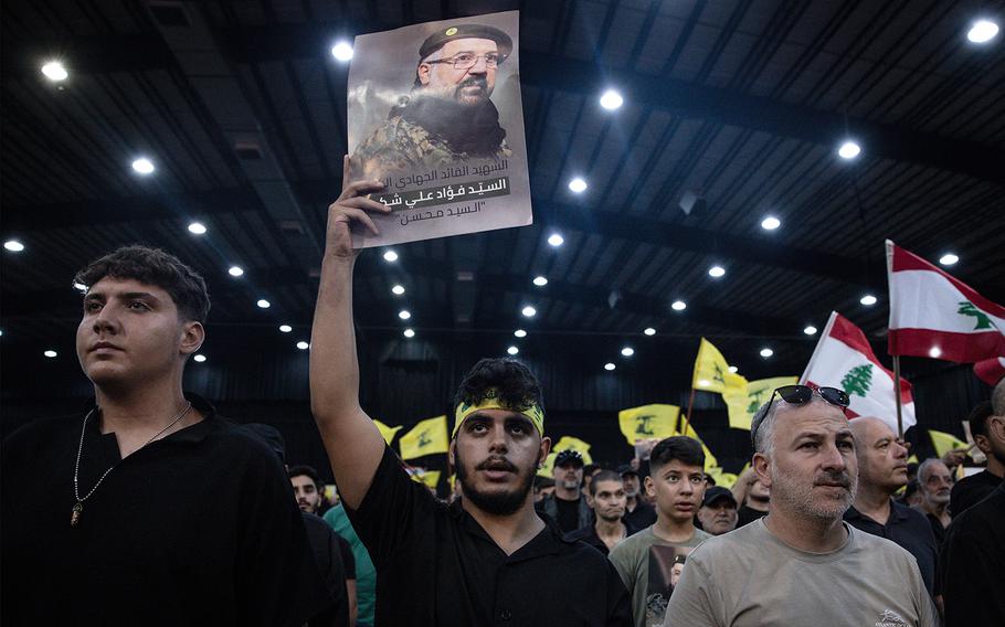 A supporter holds a poster of Hezbollah’s top commander Fuad Shukr on Aug. 6, 2024, in Beirut, Lebanon, during a ceremony to mark the first week since his death.