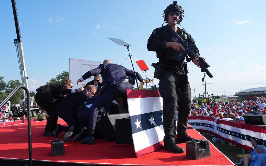 Secret Service agents cover former president Donald Trump after gunfire exploded during a campaign rally on Saturday, July 13, 2024, in Butler, Pa. 