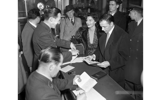 Rhein-Main Air Base, Germany, Dec. 12, 1951: Ava Gardner grants one of her magnetic smiles to a young German customs official after arriving at Rhein-Main Air Base with her newly minted husband, Frank Sinatra. The actress and singer - who got married just over a month ago - are in Germany to perform in Hollywood's "Surprise Package" show next week. The show - filled with song, dance and comedy routines - also stars Tony Curtis and Janet Leigh, among others.

Looking for Stars and Stripes’ historic coverage? Subscribe to Stars and Stripes’ historic newspaper archive! We have digitized our 1948-1999 European and Pacific editions, as well as several of our WWII editions and made them available online through https://starsandstripes.newspaperarchive.com/

META TAGS: USO; celebrity; actor; entertainment; culture; singer; airport; arrival