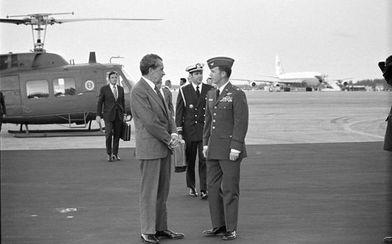 In this photo obtained by the National Security Archive from the Richard M. Nixon Presidential Library, Nixon speaks with senior Air Force officers, with Presidential Emergency Satchel carrier Lt. Commander T. Stephen Todd in the immediate background, at Homestead Air Force Base, Fla., on March 11, 1974. (Richard M. Nixon Presidential Library/National Security Archive - nsarchive.gwu.edu via AP)