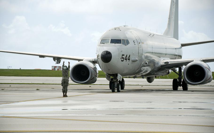 A petty officer conducts preflight checks with P-8A Poseidon pilots.