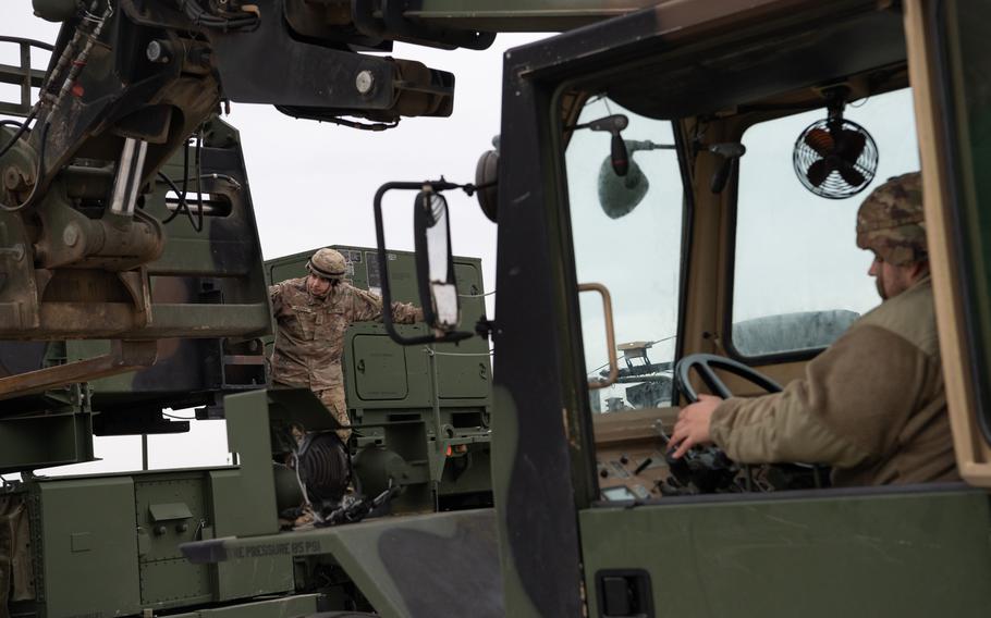 A soldier in a truck works to remove missiles.