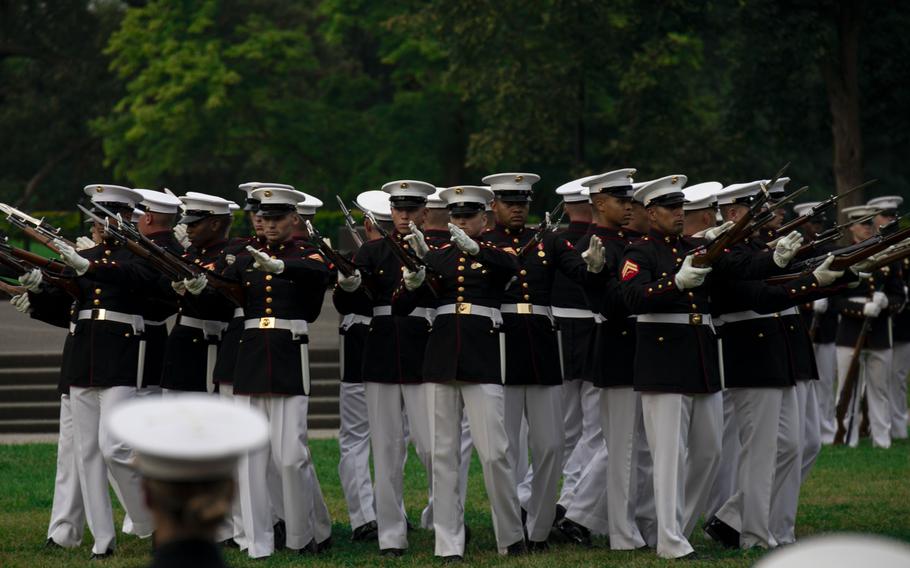 Marines with the U.S. Marine Corps Silent Drill Platoon, Marine Barracks Washington, execute their “bursting bomb” sequence during a Sunset Parade at the Marine Corps War Memorial, Arlington, Va., July 23, 2024. 