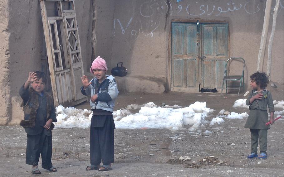 Children in the Pashtun Zarghun district of Herat province wave at a joint patrol of U.S. forces and Afghan National Police on Feb. 8, 2010. A strong police commander and U.S. mentoring have helped win popular support for the government forces.