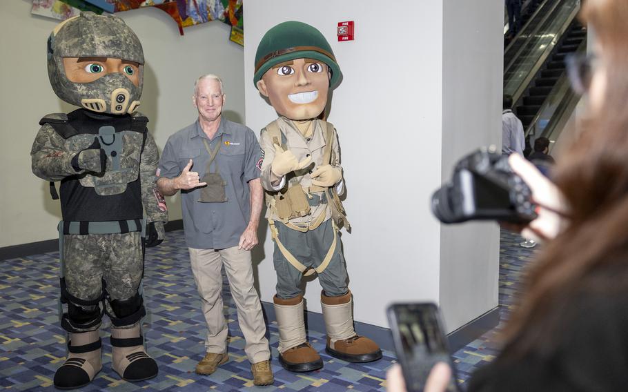 An attendee poses with AUSA mascots