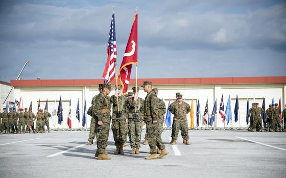 First Sgt. Rigoberto Melendez, left, and Lt. Col. Scott Caton, commander of the 12th Littoral Anti-Air Battalion, reveal the unit's colors during an activation ceremony at Camp Hansen, Okinawa, Dec. 5, 2024.