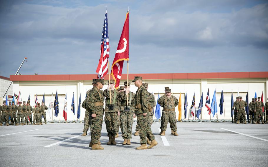 Marines hold the American flag and the unit’s colors during a ceremony at Camp Hansen.