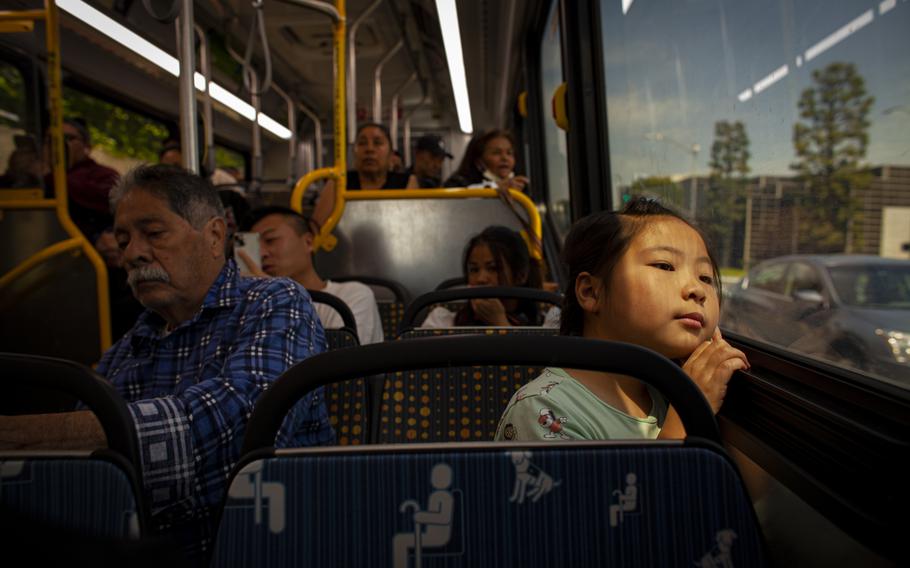 Lei Muhan, 10, peers out of a bus window in Los Angeles.