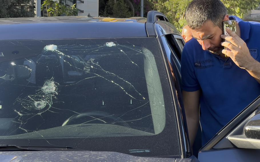 A police officer inspects a car in which a hand-held pager exploded, in Beirut, Lebanon.