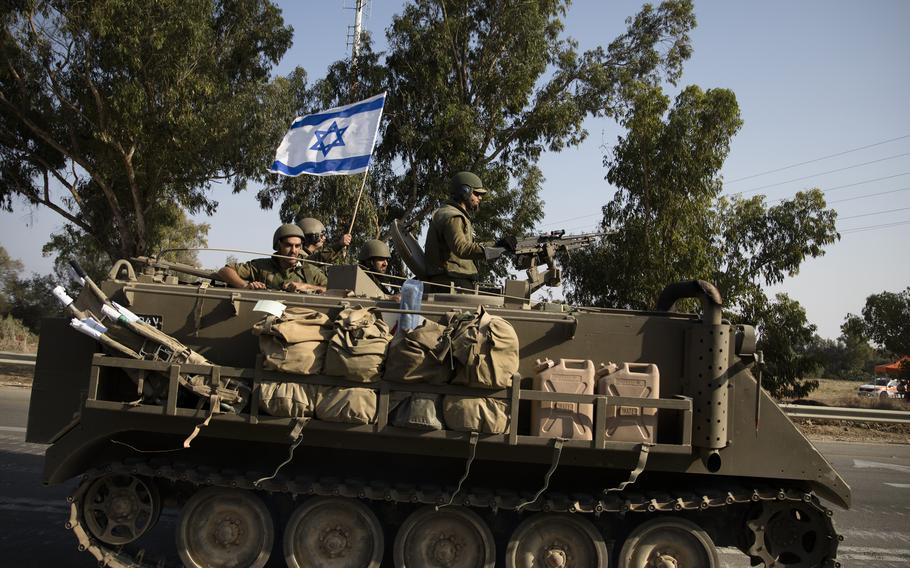 Israeli soldiers in an armored personnel carrier head towards the southern border with the Gaza Strip on Oct. 8, 2023, in Sderot, Israel. 