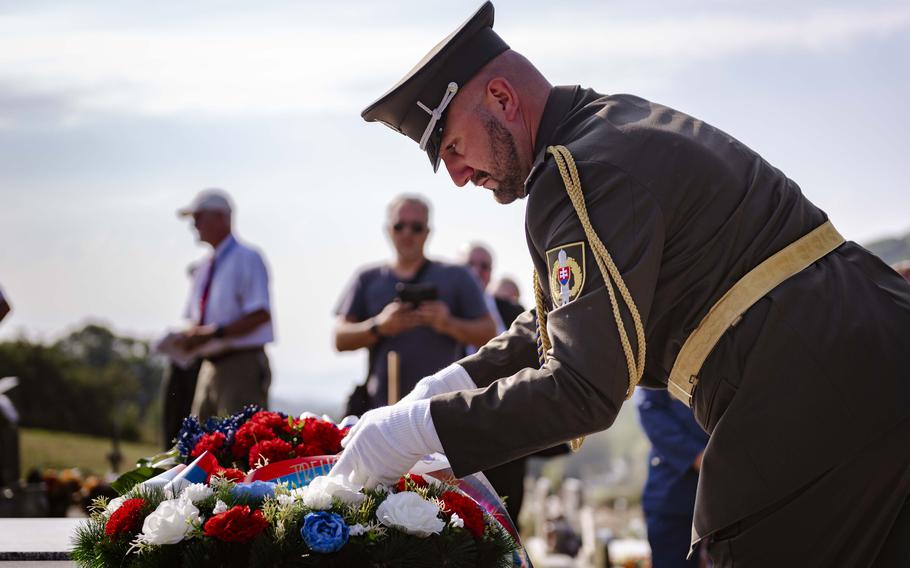 A Slovakian soldier lays a wreath at the grave of a fallen American WWII soldier during the 80th commemoration of the Battle over the White Carpathians in Nova Bosaca, Slovakia, Aug. 30, 2024. 