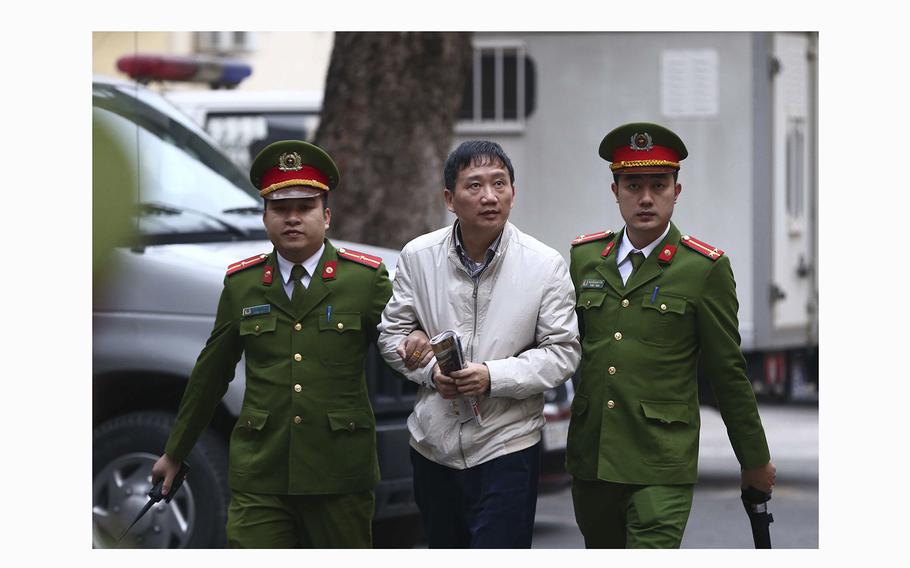 Trinh Xuan Thanh, center, is led into a courtroom by police in Hanoi, Vietnam, on Jan. 24, 2018. 