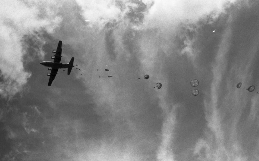 Parachutes unfold as paratroopers jump out of a C-130. The paratroopers were some of the 550 reenacting the 101st Airborne Division D-Day jump. Nineteen of them were veterans of the actual landing 50 years ago who had fought to liberate the small town of Sainte-Mère-Église. They were the first to jump, together with 22 other World War II combat paratrooper veterans. 