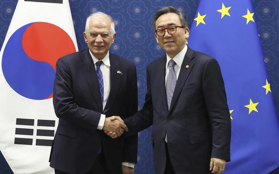 South Korean Foreign Minister Cho Tae-yul shakes hands with European Union foreign policy chief Josep Borrell while standing in front of South Korean and EU flags.