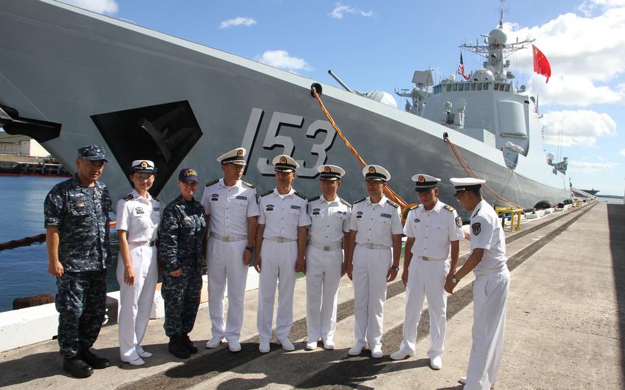 Chinese officers attending the Rim of the Pacific exercise line up to pose in front of the guided-missile destroyer Xian at Joint Base Pearl Harbor-Hickam, Hawaii, July 8, 2016. They are joined by two U.S. Navy officers who served as translators for visiting reporters.