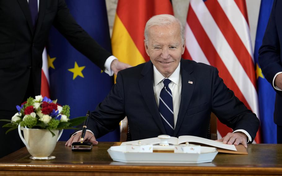 President Joe Biden signs a guest book during the welcoming ceremony at Bellevue Palace in Berlin, Germany, Friday, Oct. 18, 2024. 