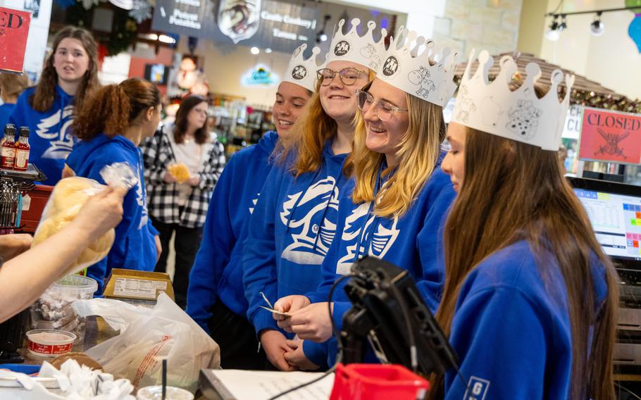 Collegiate volleyball players from Michigan wearing Mars Cheese Castle crowns.