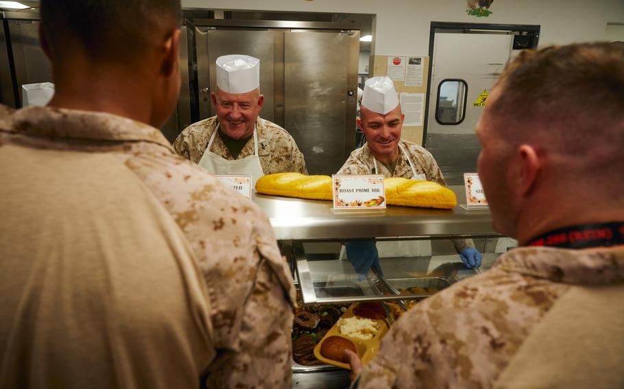 U.S. Marine Corps Maj. Gen. Robert B. Sofge Jr., Commander, U.S. Marine Corps Forces Europe and Africa, left, and gt. Maj. Roland R. McGinnis, Sergeant Major of MARFOREUR/AF, serve food