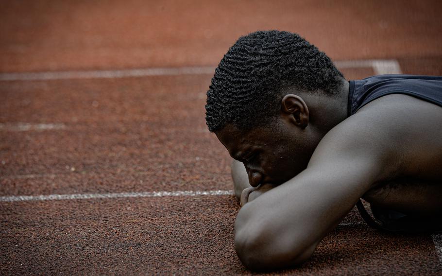Hohenfels’ Joel Idowu rests on the ground after his team finished second to last in the boys 4x400 meter relay finals at the 2024 DODEA European Championships at Kaiserslautern High School in Kaiserslautern, Germany, on May 24, 2024.