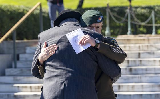 Two men embrace at a wreath-laying ceremony at Arlington National Cemetery, Va., on Oct. 17, 2024.