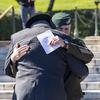 Two men embrace at a wreath-laying ceremony at Arlington National Cemetery, Va., on Oct. 17, 2024.