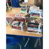 Books that have been temporarily removed recently for a compliance review are stacked up on a table in the library at Ramstein High School in Germany. Many of the books that have been singled out touch on LGBTQ+ topics. The review was prompted by recent executive orders.
