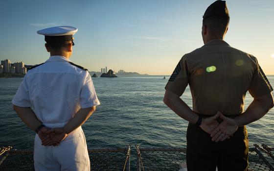 A U.S. Navy sailor attached to the amphibious assault ship the USS America (LHA 6), left, and a U.S. Marine attached to the 31st Marine Expeditionary Unit, man the rails during a scheduled port call to Busan, South Korea, during exercise Ssang Yong 24, Sept. 5, 2024. Exercise SY24 strengthens the Republic of Korea-U.S. Alliance through bilateral, joint training, contributing toward combined amphibious capability in defense of the Korean Peninsula. The 31st MEU is operating aboard ships of the USS America Amphibious Ready Group in the 7th Fleet area of operations, the U.S. Navy’s largest forward-deployed numbered fleet, and routinely interacts and operates with allies and partners in preserving a free and open Indo-Pacific region. (U.S. Marine Corps photo by Cpl. Juan Maldonado)